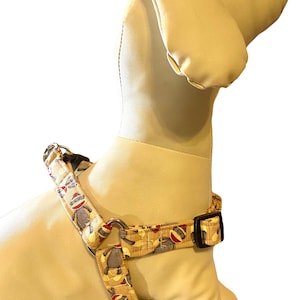 May include: A yellow dog harness with a monkey print. The harness has a black buckle and silver hardware.