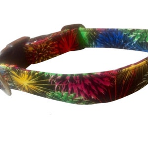 May include: A colorful dog collar with a firework pattern. The collar is black with red, yellow, green, and blue fireworks.