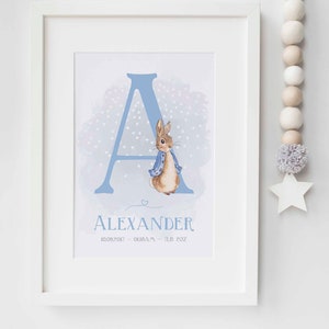 May include: A blue watercolour letter A with white hearts, featuring a Peter Rabbit illustration. The name Alexander is written below the letter with the date 10.09.2017 - 01:10 AM - 7lb 2oz.