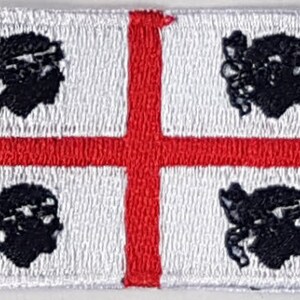 May include: A white flag with a red cross and four black stylised heads in each corner.