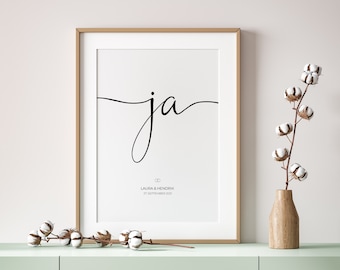May include: A white framed print with the word "ja" in black cursive script. Below the word is the text "Laura & Hendrik 27 September 2021" in black.