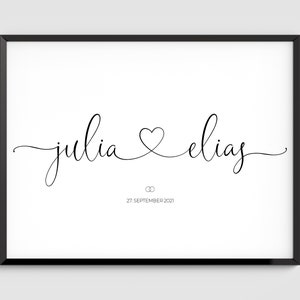 Könnte beinhalten: Schwarz-weißer Kalligrafie-Druck mit den Namen "julia" und "elias", die durch ein Herzsymbol verbunden sind. Der Text "27. SEPTEMBER 2021" befindet sich unter den Namen.
