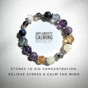 May include: A bracelet made of various coloured stones, including amethyst, blue, green, and gold. The bracelet is labelled "Anti-Anxiety Calming Bracelet" and "Stones to aid concentration, relieve stress & calm the mind."