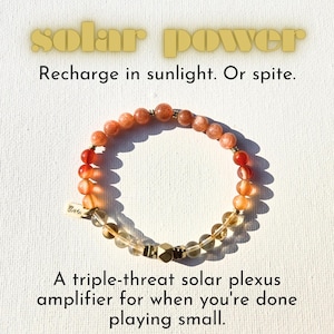 Può includere: Un braccialetto di perline arancioni, rosse e trasparenti. Il testo "solar power" è in alto, e il testo "Recharge in sunlight. Or spite." è sotto. Il testo "A triple-threat solar plexus amplifier for when you're done playing small." è anche visibile.