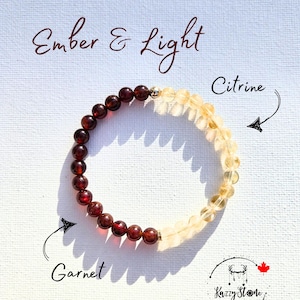 May include: A bracelet made with garnet and citrine beads. The bracelet is labeled "Ember & Light" with "Garnet" and "Citrine" labels pointing to the corresponding beads. The bracelet is made by "Kizzy Stone".