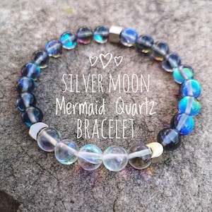 Op de afbeelding: Een zilveren maan-zeemeermin-kwartsarmband met iriserende blauwe en heldere kralen. De armband heeft een zilveren magneetsluiting.