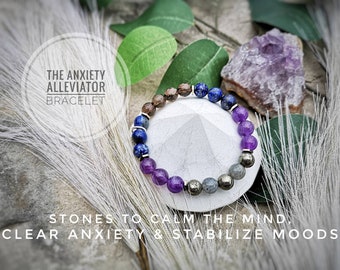 May include: A bracelet made with amethyst, lapis lazuli, pyrite, and smoky quartz stones. The bracelet is on a white background with a purple amethyst crystal and a sprig of green leaves. The text "THE ANXIETY ALLEVIATOR BRACELET" is in a circle above the bracelet. The text "STONES TO CALM THE MIND, CLEAR ANXIETY & STABILIZE MOODS" is below the bracelet.