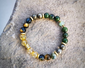May include: A multi-colored beaded bracelet with gold accents. The bracelet features green, blue, and yellow beads.