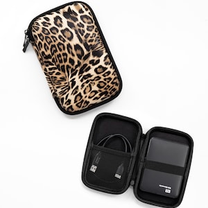 Può includere: Due custodie con cerniera, una con un design a stampa leopardata e l'altra nera con una tasca a rete e un disco rigido esterno nero con l'etichetta "WD Elements 2TB HD", all'interno.