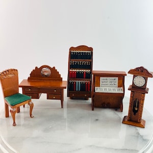 Puede incluir: Un conjunto de muebles de madera en miniatura para una casa de muñecas, que incluye un escritorio con espejo, una silla, una librería, un piano y un reloj de pie.