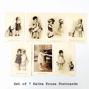 Op de afbeelding: Set van zeven vintage Käthe Kruse-postkaarten. Elke sepia-getinte kaart toont een kind met speelgoed of in feestelijke scènes. De kaarten hebben tekst in verschillende talen, met de tekst "Set of 7 Käthe Kruse Postcards" onderaan.