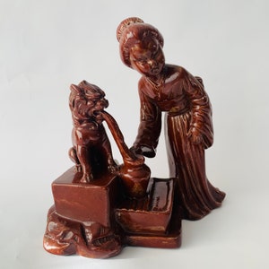 Wunderschöne Figur einer Chinesin mit einem Foo-Löwenhund, der mit seiner Zunge aus einem Gefäß leckt, chinesischer Wächterlöwenhund, Art-Deco-Figur