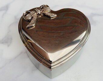 Vintage metal Jewelery Box in the shape of a Heart, with a Silver Plated Bow on the Lid.