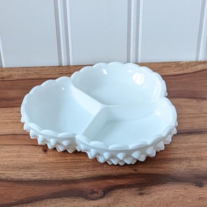 Peut inclure: Plat en verre de lait blanc divisé avec un bord festonné et un motif de points texturés en relief. Le plat comporte trois sections.