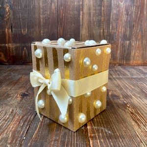 Luxuriöse Geschenkbox aus Kraftpapier mit Blattgoldstreifen und elfenbeinfarbener Schleife – Mit Perlen verzierte Verpackung für besondere Anlässe