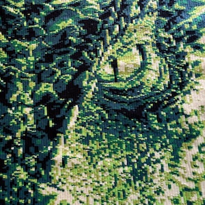 Op de afbeelding: Abstracte textielkunst in tinten groen, blauwgroen en zwart. Het ontwerp heeft een gepixeld, gestructureerd patroon dat doet denken aan een bos of landschap. Het kleurenpalet omvat verschillende groentinten, waardoor een visueel aantrekkelijk en artistiek stuk ontstaat.