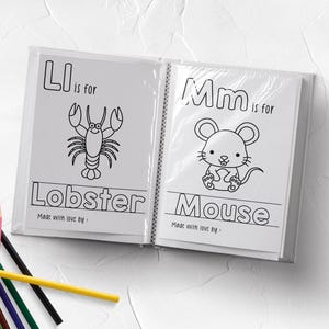May include: An open educational coloring book featuring black and white line art of a lobster with the text 'Ll is for Lobster' and a mouse with the text 'Mm is for Mouse', accompanied by a collection of multi-colored sharpened pencils.