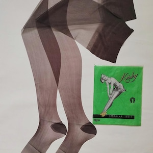 May include: Sheer brown stockings with a gradient effect, displayed next to a green package with a vintage illustration and the text "Kirby Circular Knit". The stockings have reinforced toes and heels.