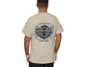 May include: A beige t-shirt featuring a graphic on the back. The graphic includes the text "In Loving Memory of" above a firefighter emblem with wings. The emblem includes names and dates. The words "Never Forget" are below the emblem.