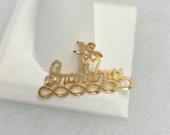 May include: Gold charm necklace with the word "Grandma" and a small angel figure.