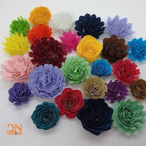May include: Assortment of paper flowers in various colours, including red, green, blue, purple, yellow, and brown. The flowers are all made of paper and have a layered, three-dimensional appearance.