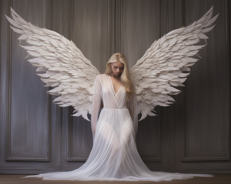 Puede incluir: Una mujer con un vestido blanco y grandes alas blancas de plumas detr&aacute;s de ella. Las alas est&aacute;n extendidas y la mujer mira hacia abajo.
