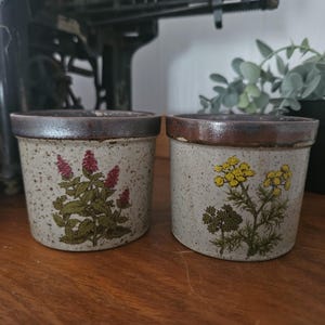 Puede incluir: Un juego de tres tazas de cerámica con acabado mate moteado. Las tazas son en tonos crema, gris claro y gris oscuro. Cada taza tiene un diseño simple y minimalista y un asa redondeada. Para café o té.