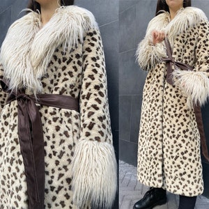 May include: A long-sleeved leopard print faux fur coat with a brown leather belt and white faux fur trim around the collar and cuffs.