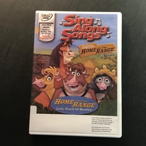 May include: A Disney DVD case for "Sing Along Songs" featuring songs from "Home on the Range." The cover art showcases cartoon cows, a horse, and the text "Little Patch of Heaven." The case includes text about karaoke and reading skills.