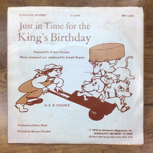 Peut inclure: Une pochette d'album vintage avec une illustration de dessin anim&eacute; d'un gar&ccedil;on poussant une brouette pleine d'animaux. L'album est intitul&eacute; "Just in Time for the King's Birthday" par E. B. Chance. L'album est une sortie de Scholastic Records.