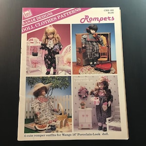 May include: A pattern book titled "Rompers" by Banar Designs, featuring four doll outfits. The cover displays images of dolls in various romper styles. The text reads "4 cute romper outfits for Wangs 16" Porcelain-Look doll."