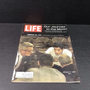 May include: A vintage LIFE magazine cover from January 17, 1969, featuring the headline "Our Journey to the Moon" and an image of men in a discussion. The cover also includes the text "Sirhan in Jail" and the price of 40¢.