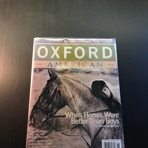 May include: An "Oxford American" magazine with a cover featuring a grayscale image of a horse and a person. The title "When Horses Were Better Than Boys" is visible. Additional text includes "Dirty Dancing and the KKK" and "Teddy Roosevelt's Fabled Bear Hunt."