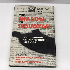 May include: A black and white book cover with the title "The Shadow of Sequoyah: Social Documents of the Cherokees 1862-1964" and the names of the translators and editors, Jack Frederick Kilpatrick and Anna Gritts Kilpatrick.