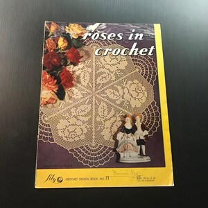 May include: A vintage crochet pattern book titled "Roses in Crochet" with a floral design on the cover. The cover features a crochet doily design, roses, and a small figurine. The book is a Lily Crochet Design Book No. 71.