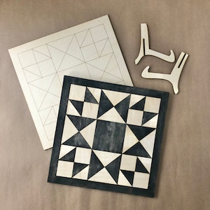 May include: Two unfinished wooden squares with geometric patterns. The smaller square has a black and white geometric pattern. The larger square has a grid pattern.