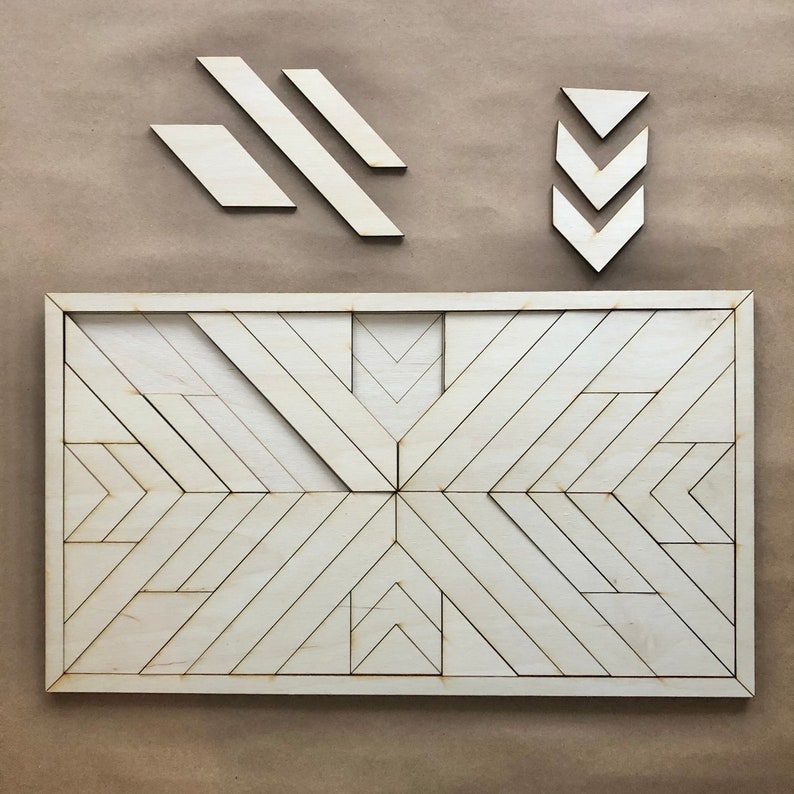 May include: A wooden geometric wall art piece with a white finish. The art is made up of multiple triangles and rectangles that create a pattern of intersecting lines. The art is framed in a thin, white frame.