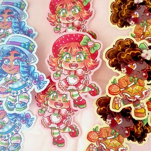 May include: A set of colourful stickers featuring cartoon characters with different hairstyles and outfits. The characters are holding various fruits and desserts, such as strawberries, blueberries, and cookies. The stickers are perfect for adding a touch of whimsy to laptops, water bottles, or journals.