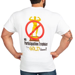 May include: White t-shirt with a red circle and a line through it, a gold trophy of a bodybuilder inside the circle. The text below reads "No Participation Trophies The GOLD is EARNED!"