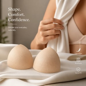 May include: Two beige, dome-shaped bra inserts resting on white fabric. Text reads: Shape. Comfort. Confidence. Elevate your everyday, naturally. Icons labeled Lightweight, Breathable, and Secure Fit are visible on the right side of the image.
