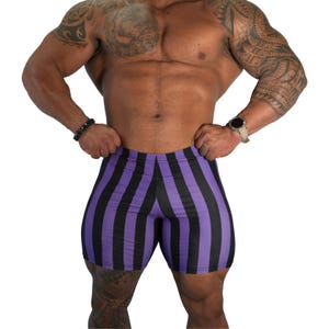 May include: Purple and black striped compression shorts. The shorts are form-fitting and feature vertical stripes. The garment is made of a stretchy material. The shorts are designed for athletic activities.
