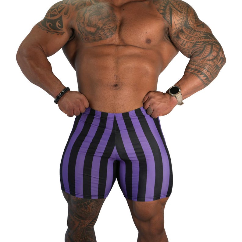 May include: Purple and black striped compression shorts. The shorts are form-fitting and feature vertical stripes. The garment is made of a stretchy material. The shorts are designed for athletic activities.