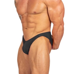 May include: Black athletic briefs. The briefs are made of a stretchy material and have a low-rise cut. The briefs are designed for athletic activities and are form-fitting.