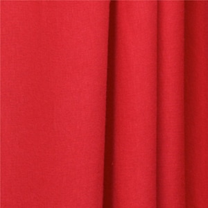 May include: Close-up of a smooth, red fabric with subtle folds and wrinkles. The fabric has a soft, even texture.