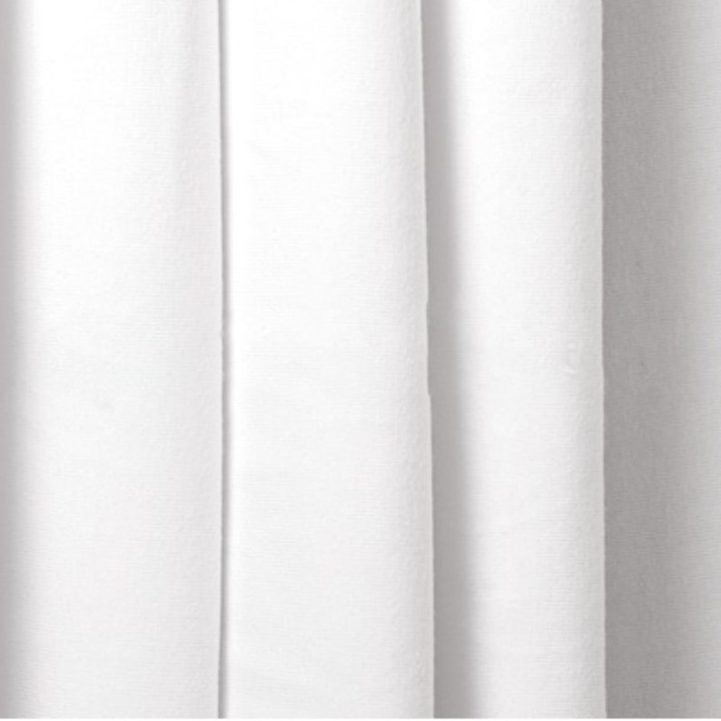 May include: White fabric with a smooth texture and a subtle sheen. The fabric is folded in pleats, creating a series of vertical lines.