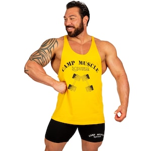 May include: A bright yellow sleeveless tank top featuring the black text CAMP MUSCLE BODYWEAR and a graphic of two dumbbells. The garment is paired with black athletic shorts that also display the CAMP MUSCLE BODYWEAR logo in white text.
