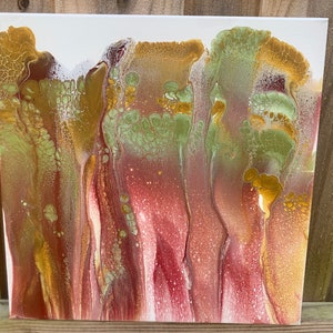 Op de afbeelding: Abstract schilderij met vloeiende lijnen van gouden, groene en rode verf op een wit doek.