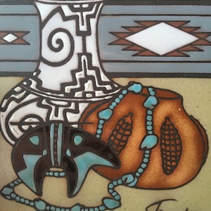 May include: A ceramic tile featuring Southwestern art. The design includes a white and black vase, a brown pot with turquoise accents, and a bear figure. The background has geometric patterns in blue and brown. The artist's signature is visible.