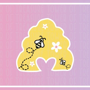 May include: A yellow honeycomb shape with a heart cut out in the middle. There are two bees flying around the honeycomb, one with a dotted line trail behind it. There are white flowers with yellow centers inside the honeycomb.