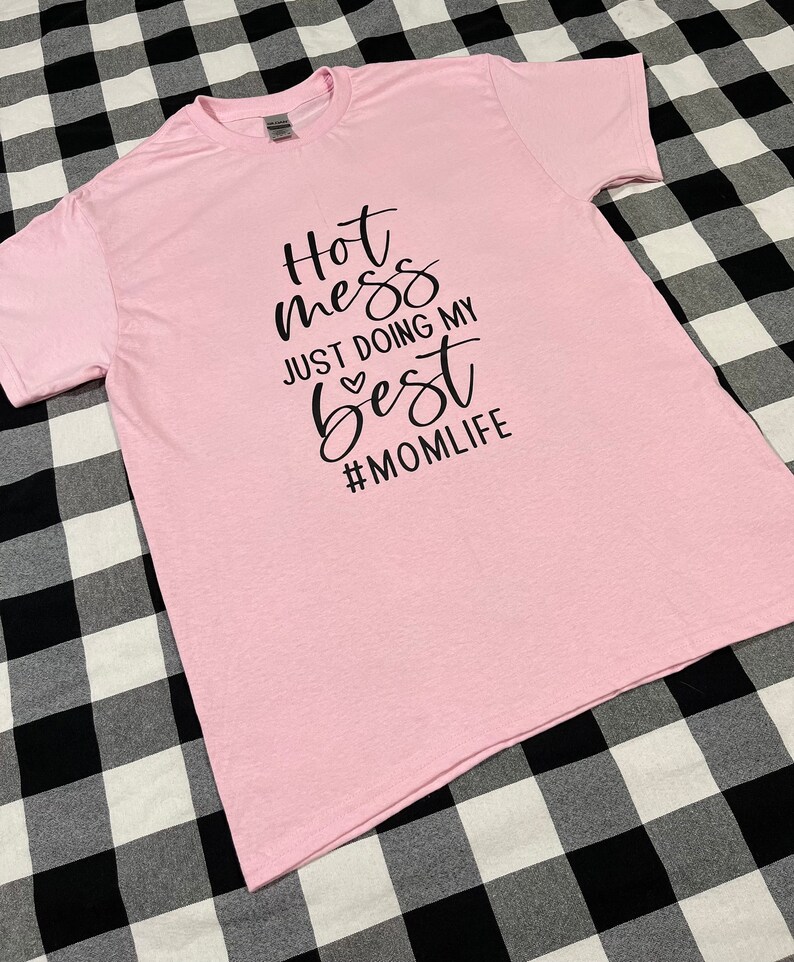 May include: Pink t-shirt with black text that reads "Hot mess just doing my best #momlife".